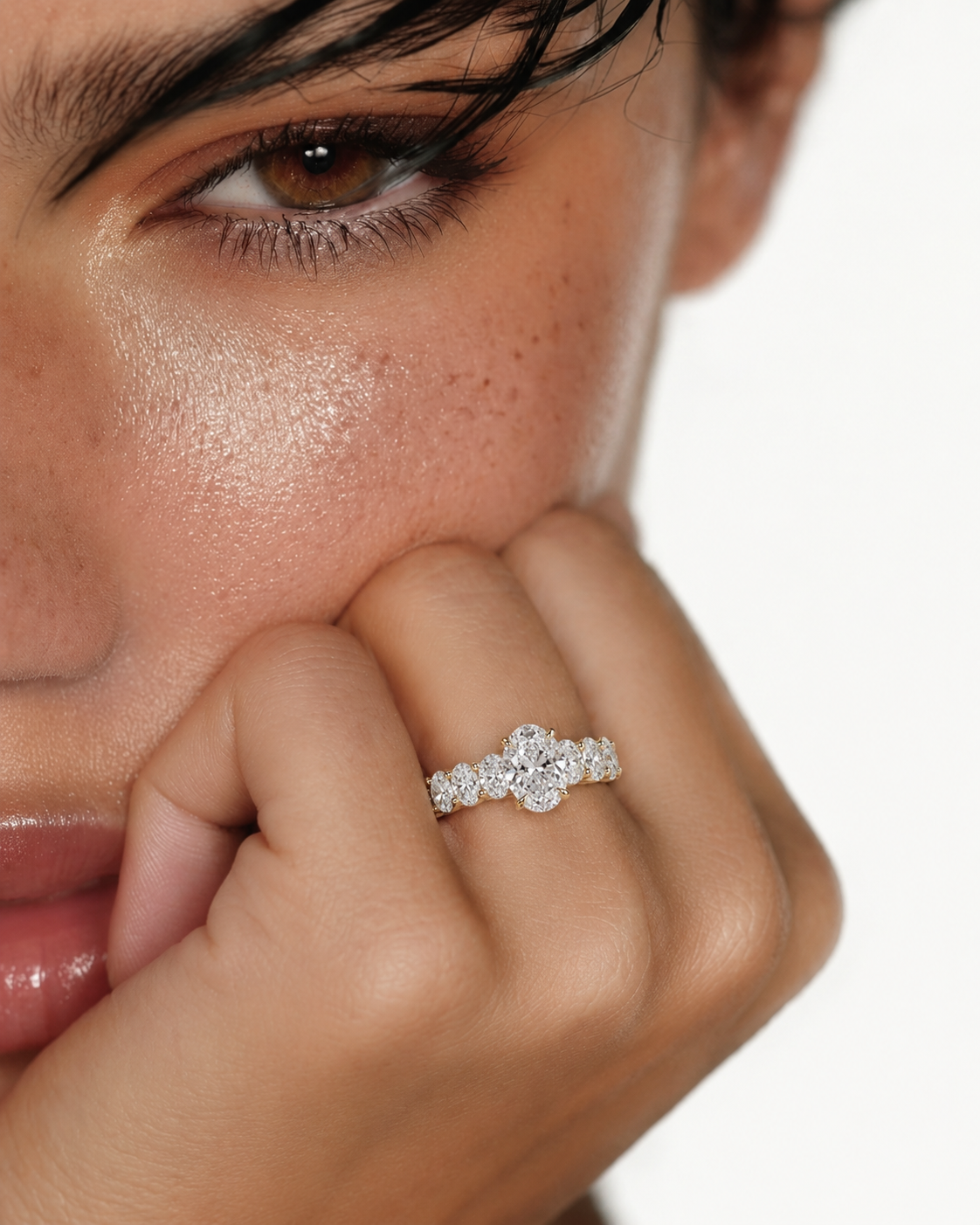 color_10K_YG, color_14K_YG &&A close-up lifestyle shot of a model wearing a silver-toned ring with a floral cluster of clear gemstones on her finger.