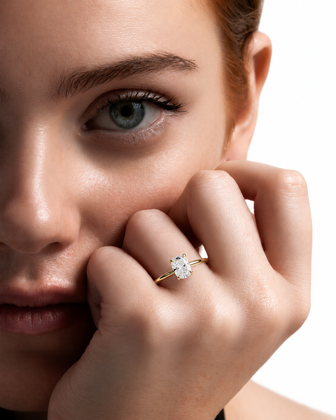 color_10K_YG, color_14K_YG &&A close-up lifestyle shot of a woman wearing a delicate yellow gold ring with a single round-cut clear gemstone on her finger, set against a clean white background.