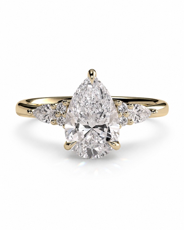 color_10K_YG, color_14K_YG &&A pear-cut diamond engagement ring in yellow gold with small side diamonds, shown on a clean white background.