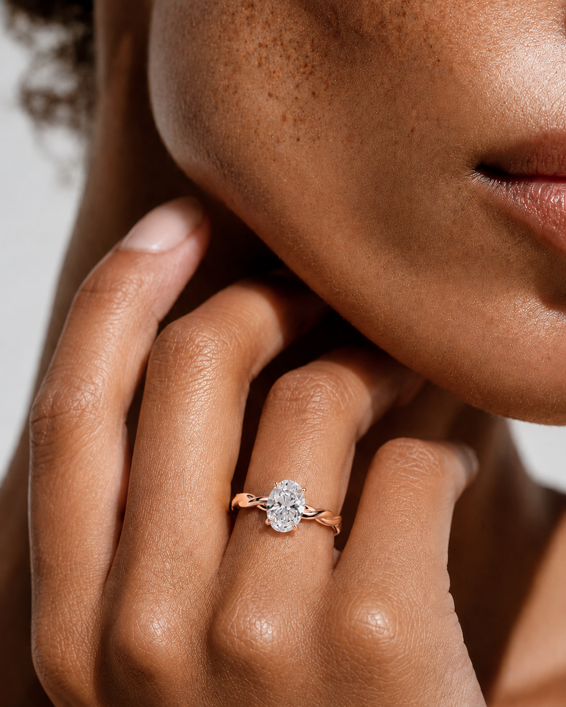 color_10K_RG, color_14K_RG &&
A close-up lifestyle shot of a model's hand wearing a rose gold ring with a clear marquise-cut gemstone.