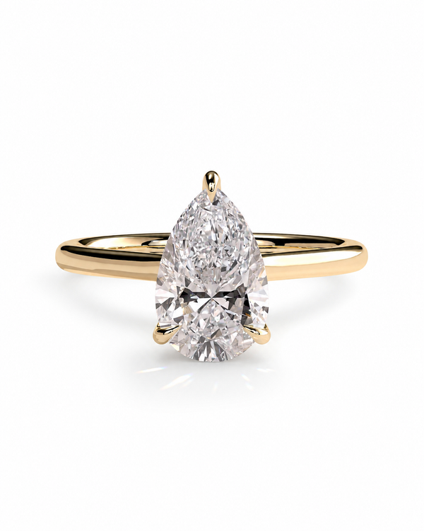 color_10K_YG, color_14K_YG &&A pear-cut diamond solitaire engagement ring set in a yellow gold band, shown on a clean white background with a soft reflection.