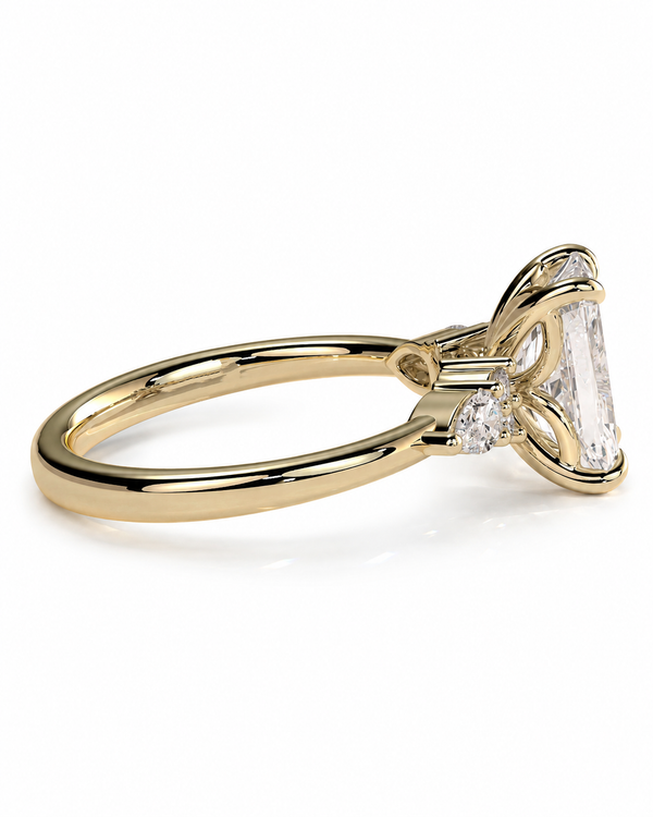 color_10K_YG, color_14K_YG &&A yellow gold ring with a large emerald-cut center stone and smaller side stones, shown on a clean white background.
