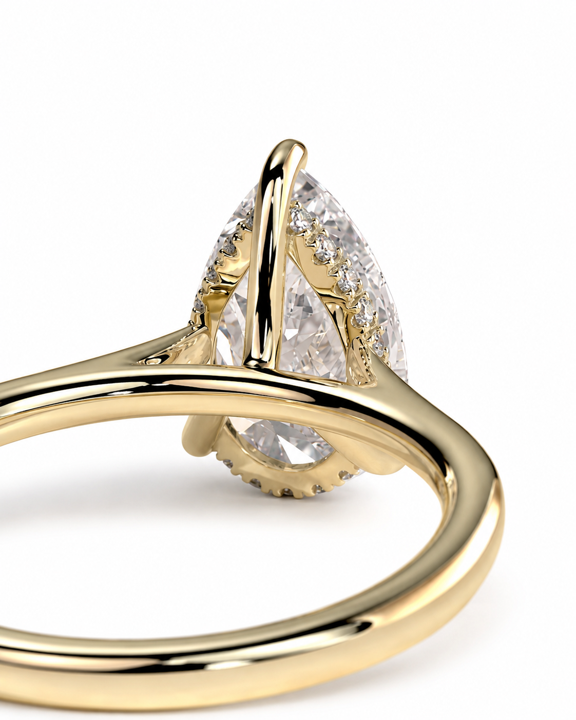 color_10K_YG, color_14K_YG &&A close-up of a gold ring featuring a pear-cut clear center stone in a prong setting with small accent stones along the band, shown on a white background.