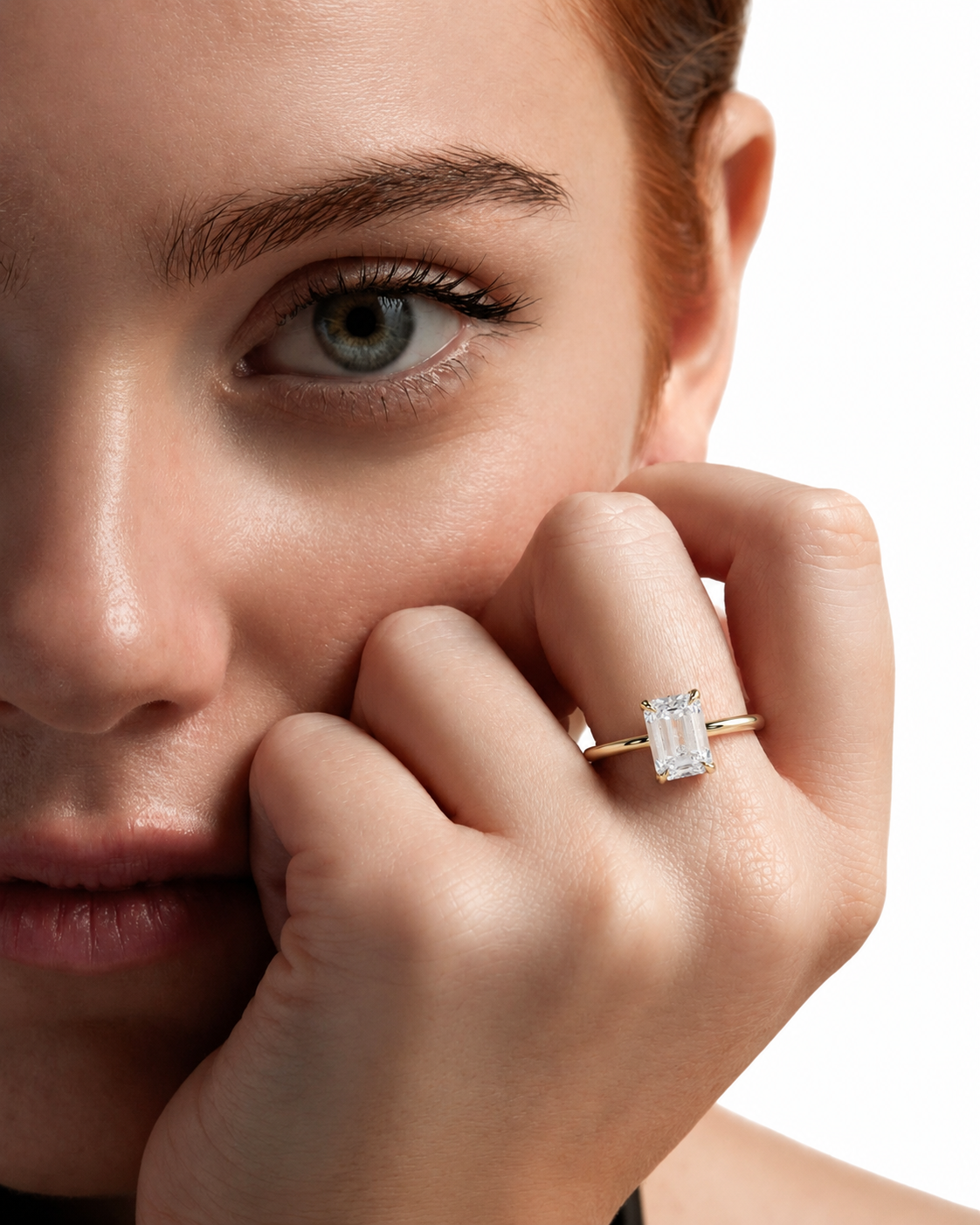 color_10K_YG, color_14K_YG &&A close-up lifestyle shot of a model wearing a gold ring with a rectangular clear gemstone on her finger, set against a clean white background.