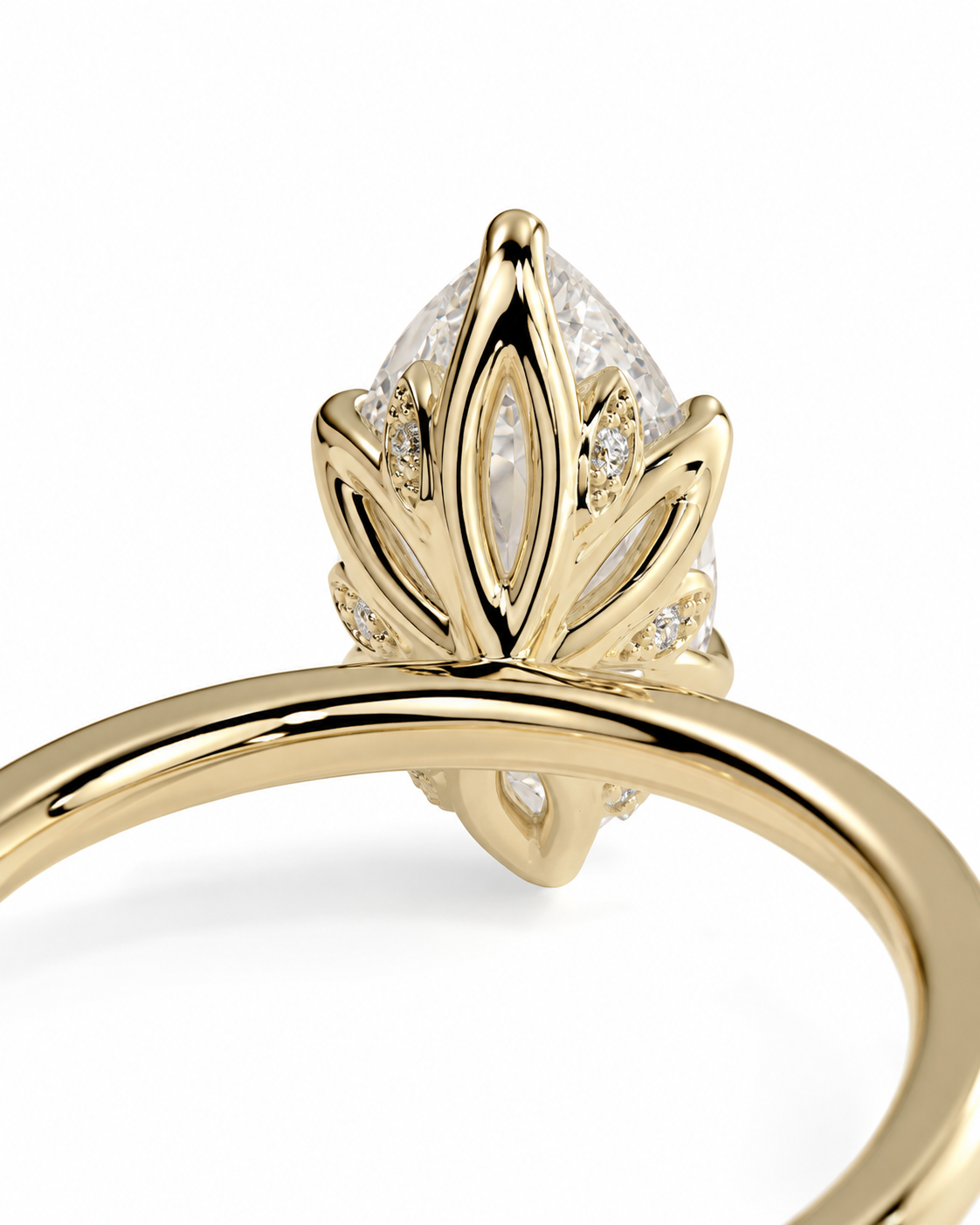 color_10K_YG, color_14K_YG &&A close-up of a yellow gold ring featuring a marquise-cut clear gemstone in a leaf-like setting with small accent stones, shown on a clean white background.