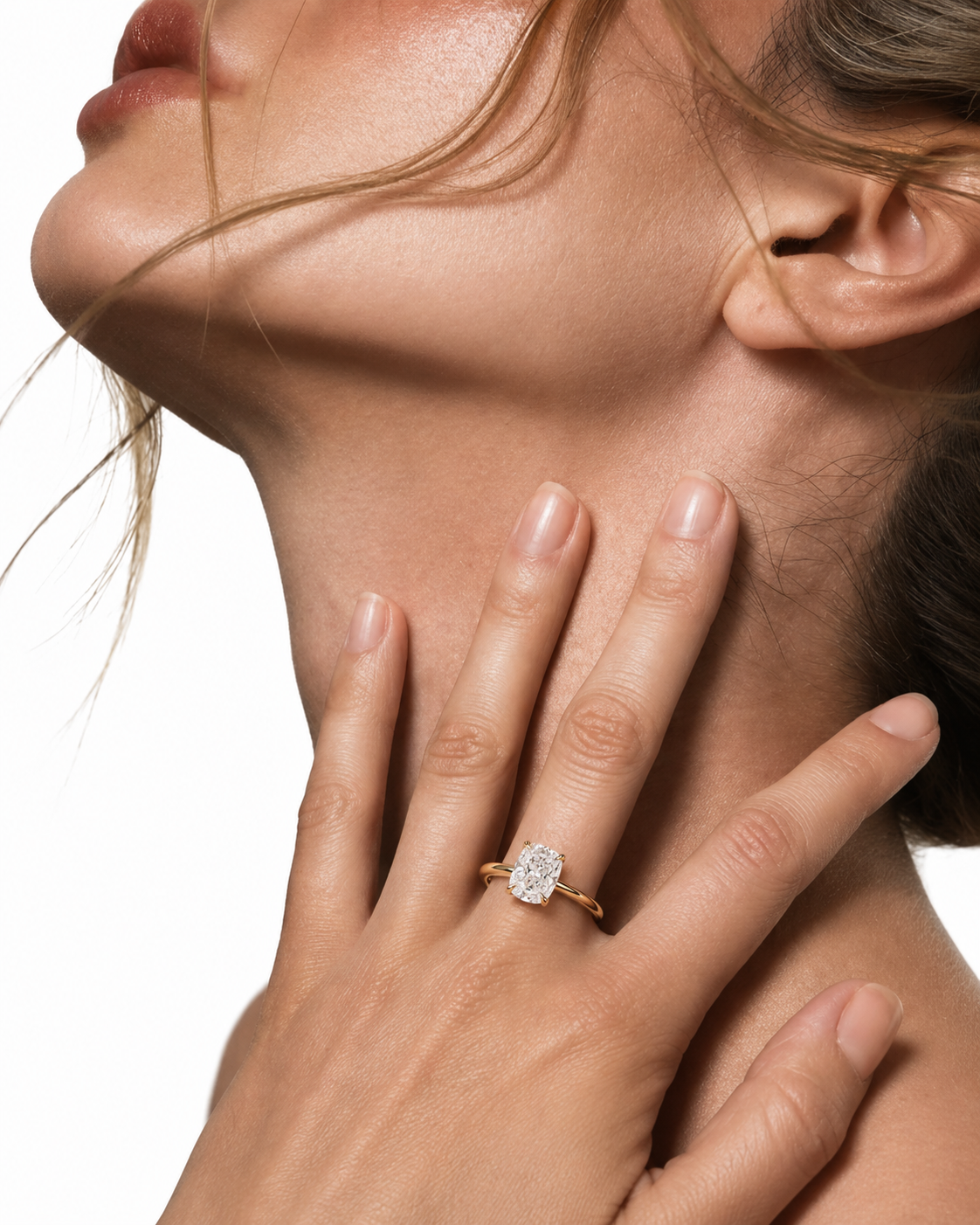color_10K_YG, color_14K_YG &&A close-up lifestyle shot of a model wearing a gold ring with a round-cut clear gemstone on her finger, set against a clean white background.