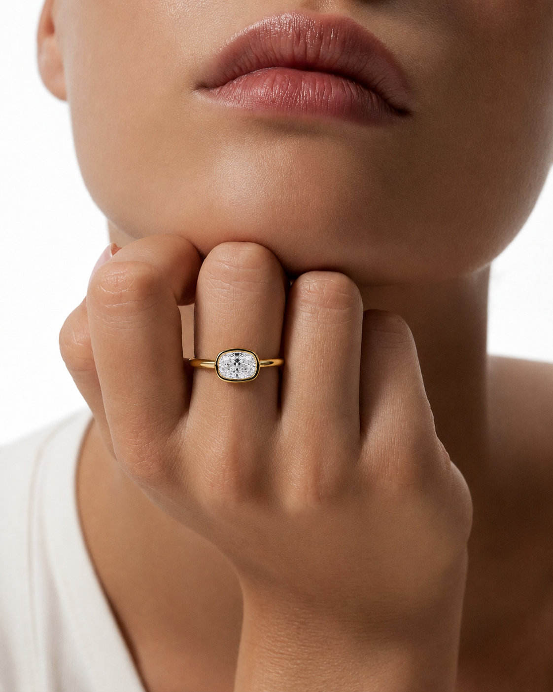 color_10K_YG, color_14K_YG &&A close-up lifestyle shot of a model wearing a gold ring with a marquise-cut clear gemstone on a white background.