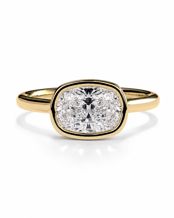 color_10K_YG, color_14K_YG &&A yellow gold ring featuring a cushion-cut diamond in an oval bezel setting, shown on a clean white background with a soft reflection.