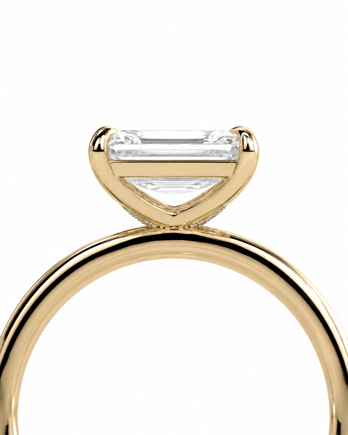 color_10K_YG, color_14K_YG &&A close-up studio shot of a yellow gold ring featuring a triangular bezel setting with a clear rectangular emerald-cut center stone and small accent stones along the band, set against a plain white background.