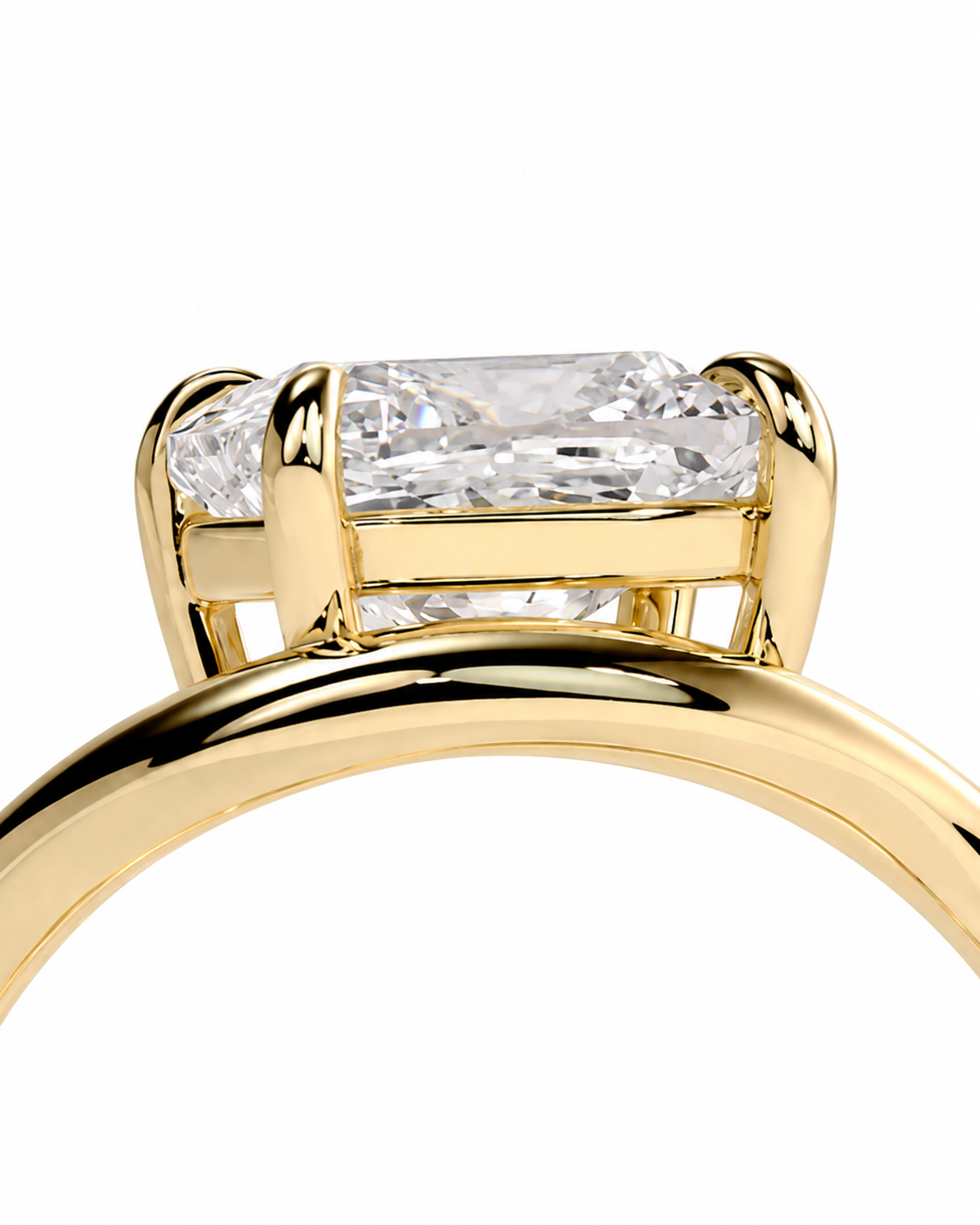 color_10K_YG, color_14K_YG &&Close-up of a yellow gold ring setting with a rectangular clear gemstone and smaller side stones on a white background.