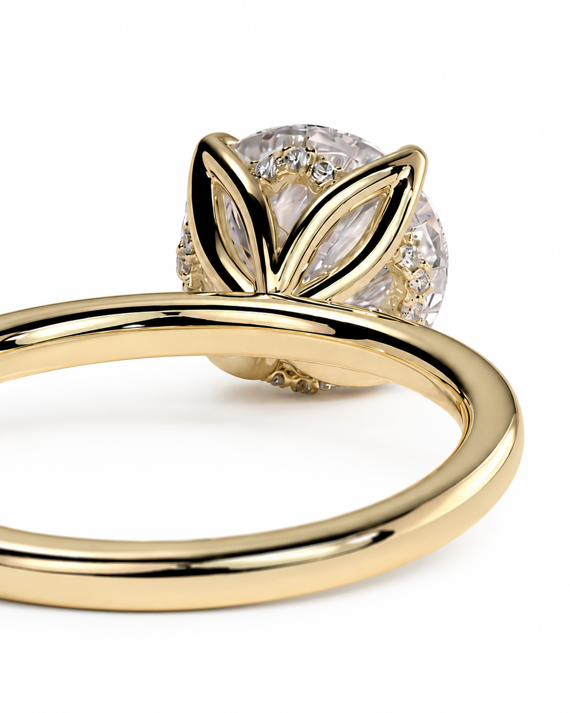 color_10K_YG, color_14K_YG &&A close-up of a yellow gold ring featuring a round clear gemstone in a leaf-like setting, with smaller accent stones, on a white background.