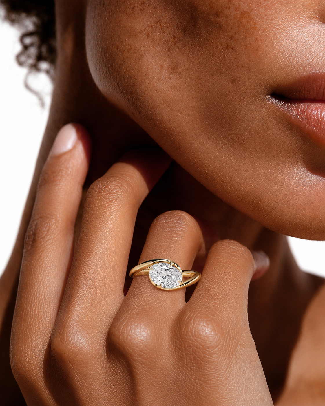 color_10K_YG, color_14K_YG &&A close-up lifestyle shot of a model's hand wearing a gold ring with a round-cut clear gemstone. The ring is shown on the ring finger against a clean white background.