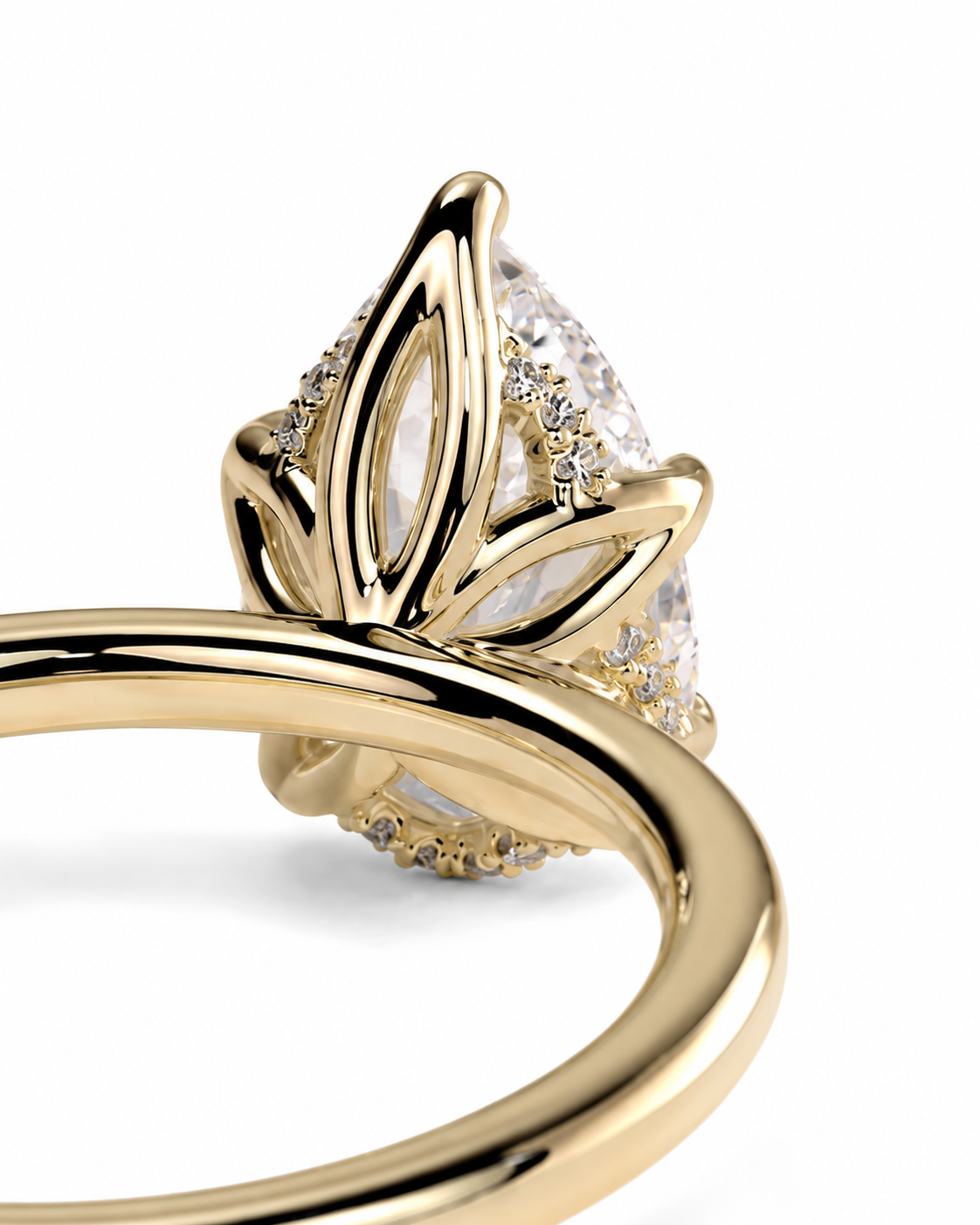 color_10K_YG, color_14K_YG &&A close-up of a gold ring featuring a pear-cut clear center stone and small clear accent stones in a leaf-like setting, shown on a white background.