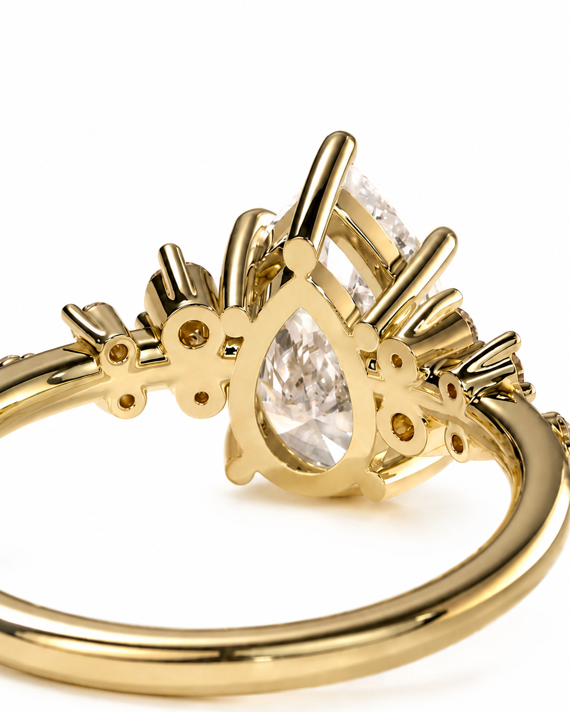 color_10K_YG, color_14K_YG &&A close-up shot of a gold ring featuring a teardrop-shaped clear gemstone in the center, surrounded by smaller round and marquise-cut clear gemstones, set against a plain white background.