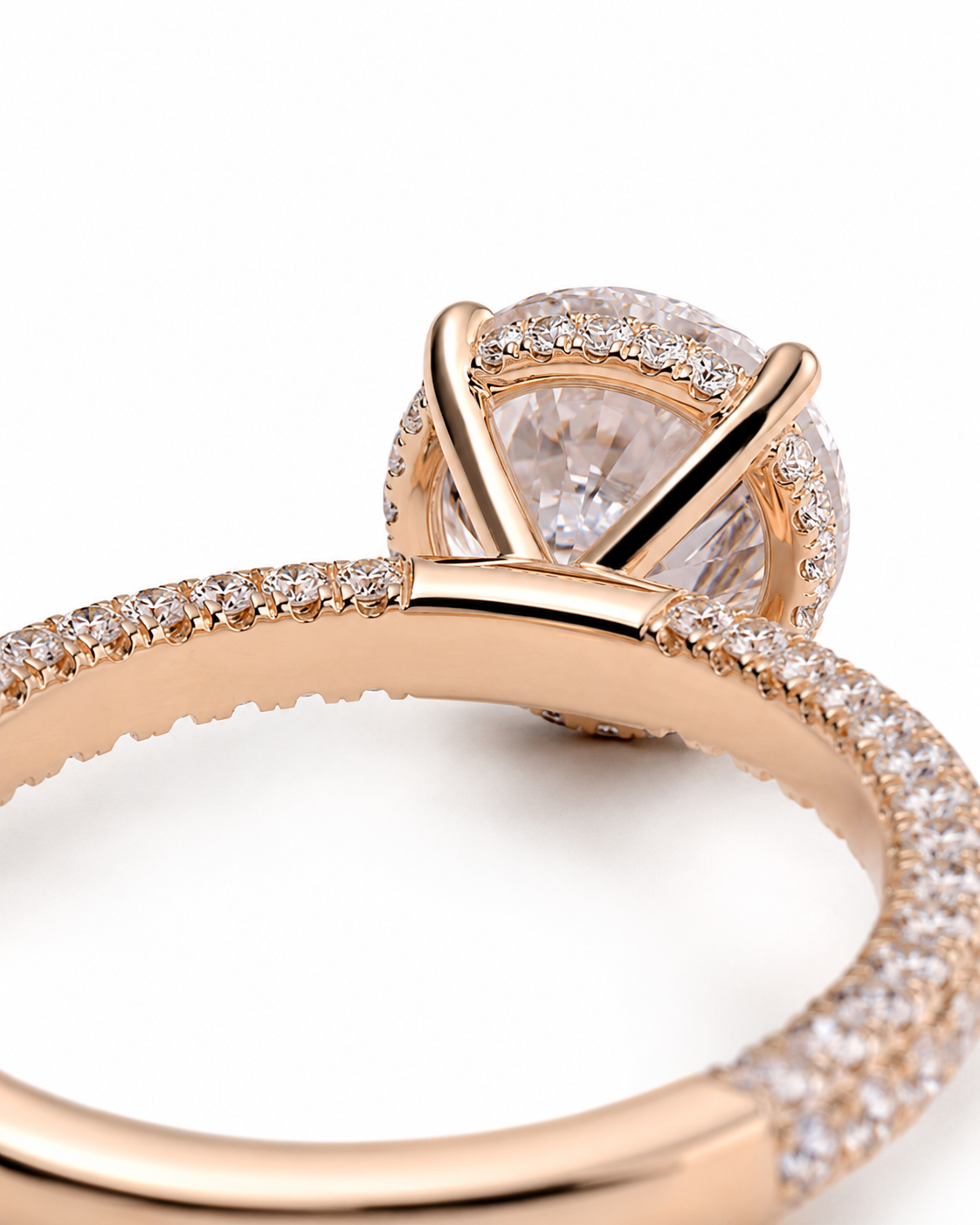 color_10K_RG, color_14K_RG &&
Rose gold engagement ring featuring a round-cut center stone surrounded by a halo of small pave-set stones, with a split shank also embellished with pave stones, shown on a white background.