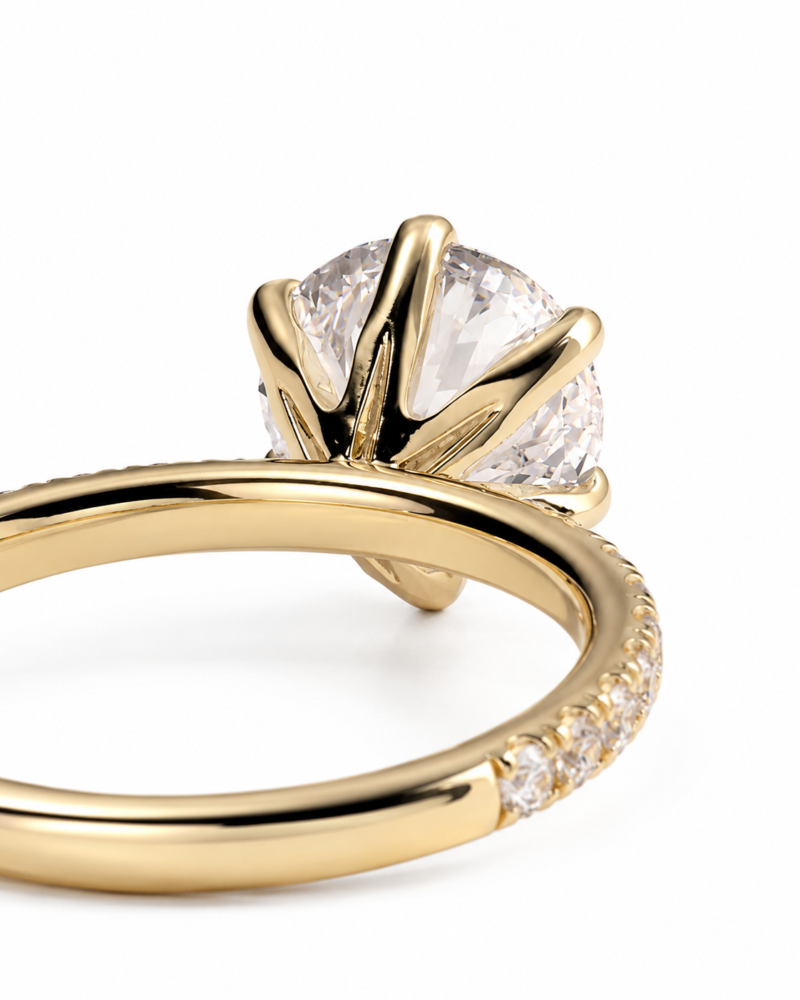 color_10K_YG, color_14K_YG &&
A close-up shot of a yellow gold solitaire engagement ring with a round brilliant-cut clear center stone and a pave band on a white background.