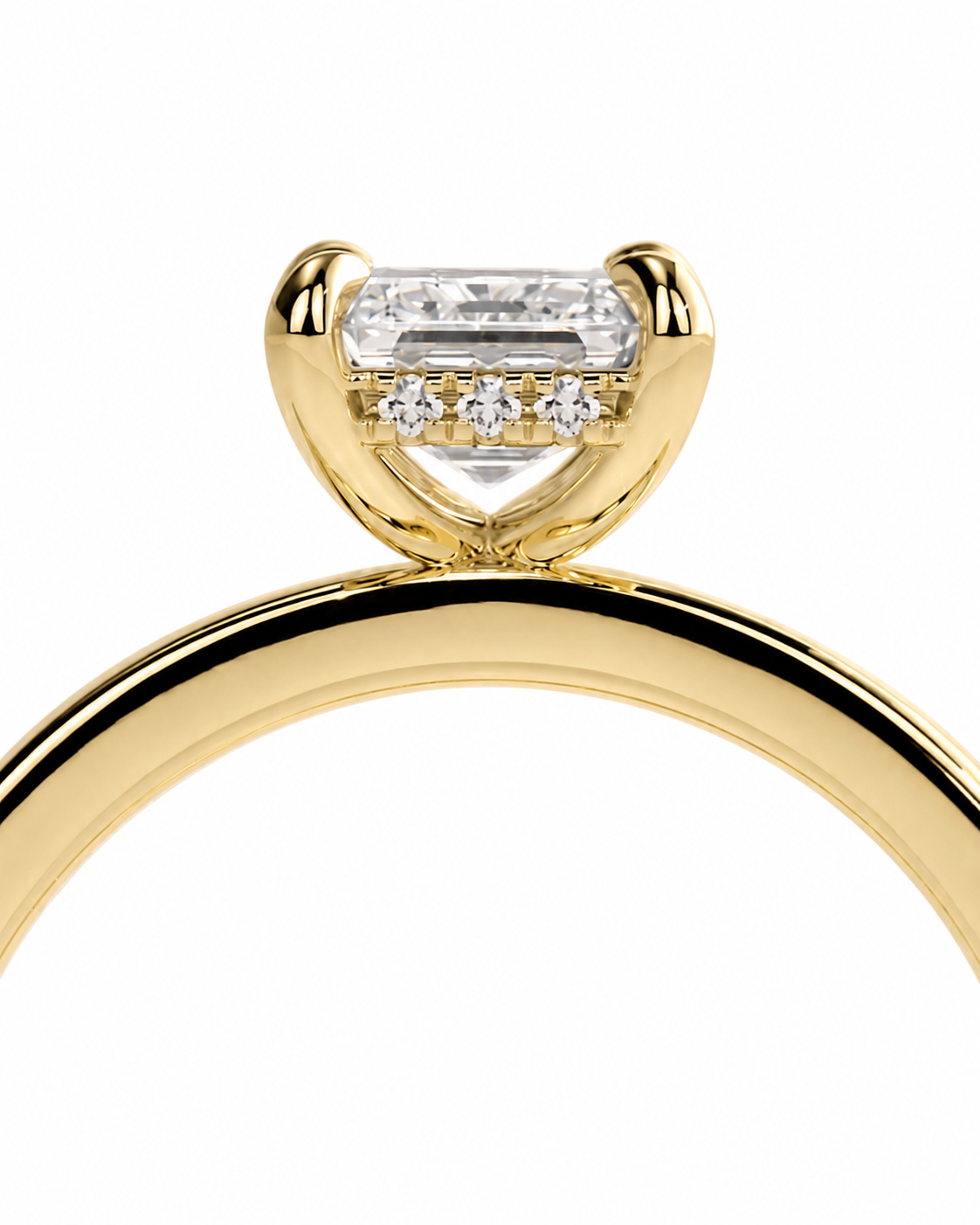 color_10K_YG, color_14K_YG &&A close-up of a yellow gold ring featuring a large emerald-cut center stone and three smaller round stones in a curved halo setting, shown against a plain white background.