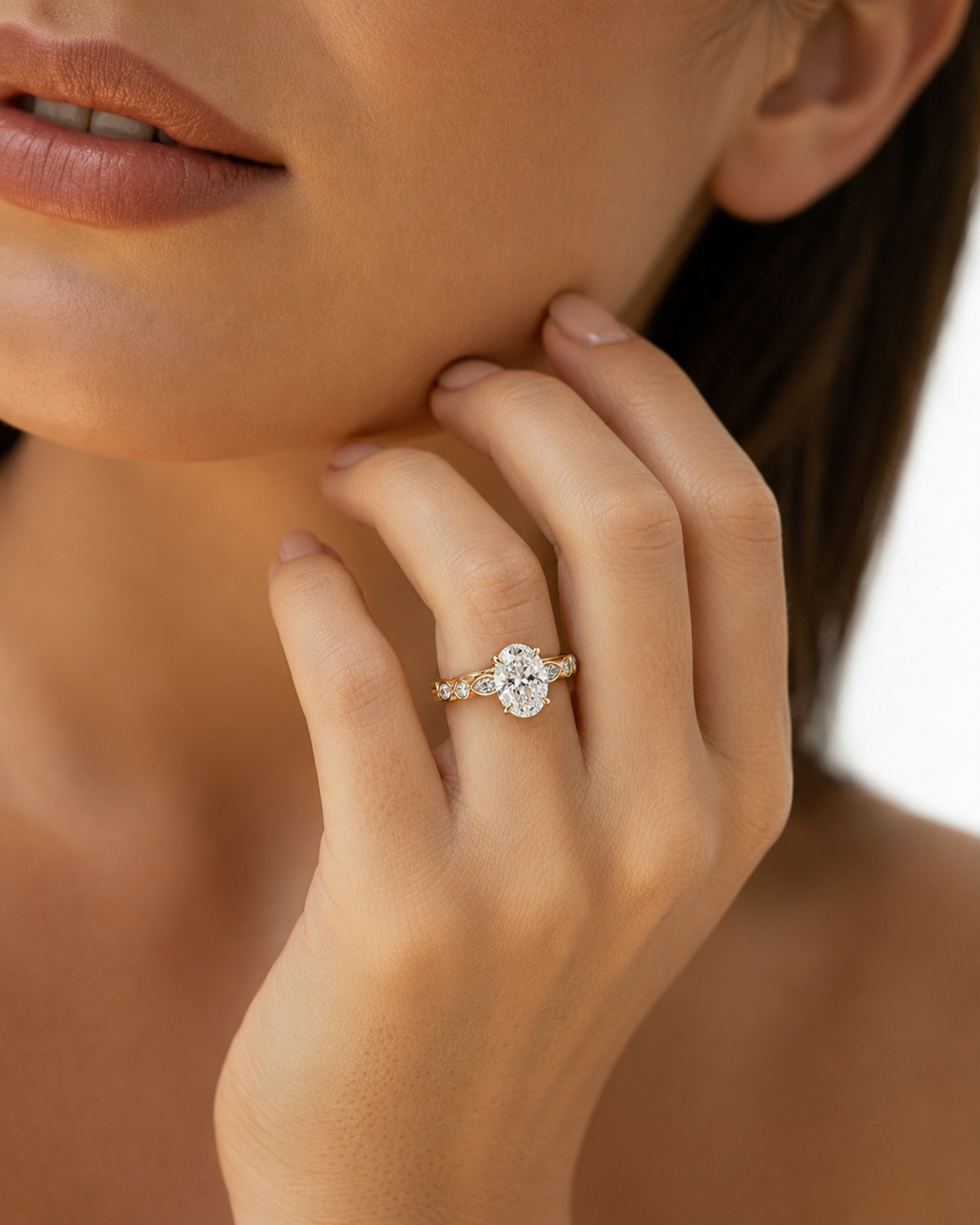 color_10K_YG, color_14K_YG &&A close-up lifestyle shot of a model wearing a yellow gold engagement ring with a round-cut diamond center stone and smaller side stones on a plain white background.