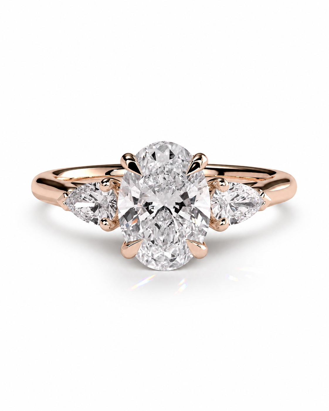 color_10K_RG, color_14K_RG &&
A rose gold engagement ring featuring a large oval center diamond flanked by two smaller pear-cut side diamonds, set against a clean white background.