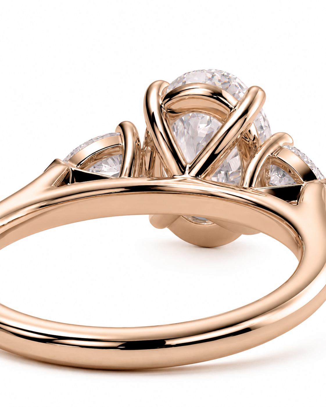 color_10K_RG, color_14K_RG &&
A close-up of a rose gold ring featuring a large pear-cut center stone and smaller side stones in a prong setting, shown on a clean white background.