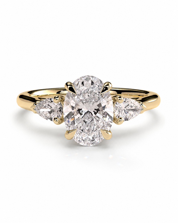 color_10K_YG, color_14K_YG &&
A yellow gold diamond ring with a large oval center stone and two pear-cut side stones, shown on a clean white background.