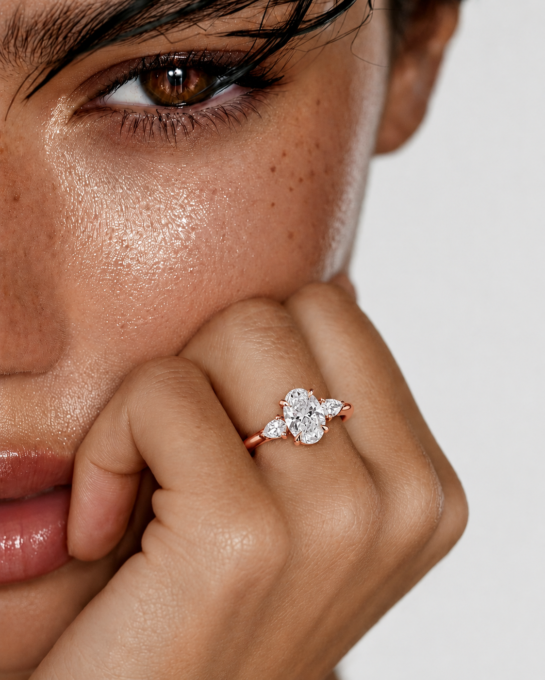 color_10K_RG, color_14K_RG &&
A close-up lifestyle shot of a model wearing a rose gold ring with a diamond cluster setting on her finger.