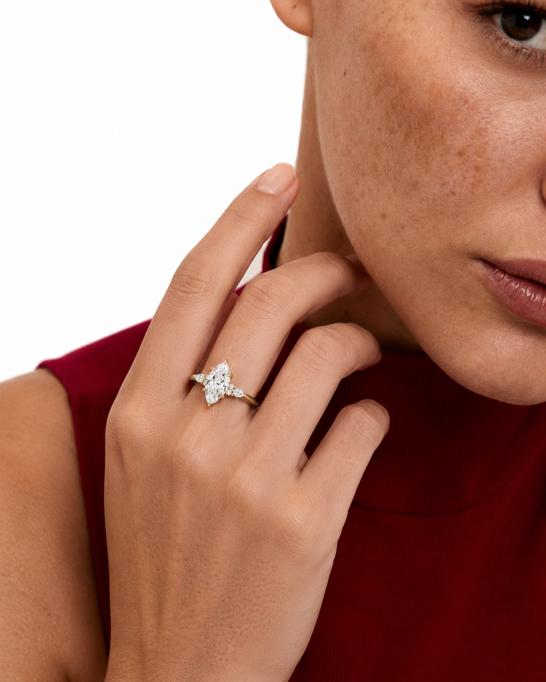 color_10K_YG, color_14K_YG &&A close-up lifestyle shot of a model wearing a diamond ring with a star-shaped cluster setting on her finger, paired with a dark red top against a clean white background.