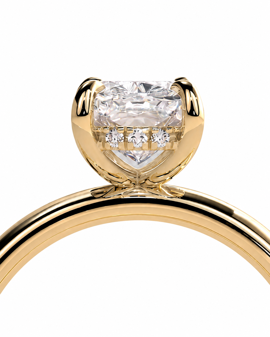 color_10K_YG, color_14K_YG &&A close-up of a yellow gold ring featuring a large heart-shaped clear gemstone in a prong setting, with three smaller round diamonds lined up beneath the center stone. The polished gold band curves upward against a plain white background.