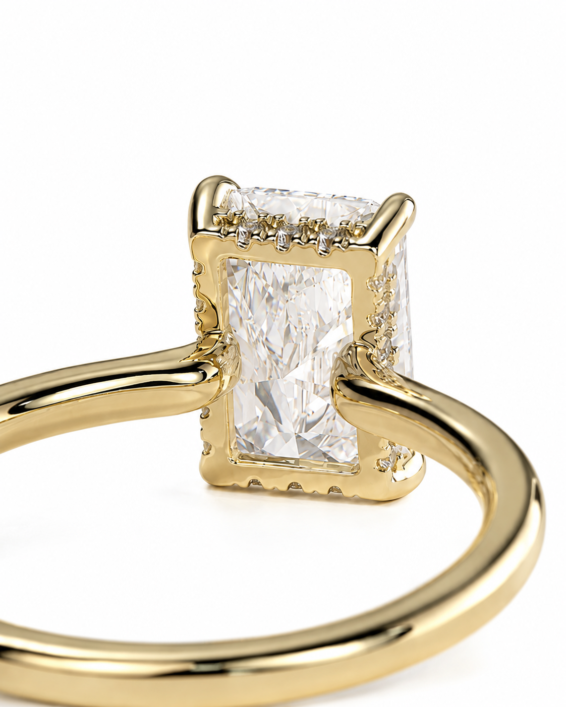 color_10K_YG, color_14K_YG &&A close-up shot of a yellow gold ring featuring a large rectangular radiant-cut clear gemstone in a prong setting, accented with small diamonds along the top border, on a white background.