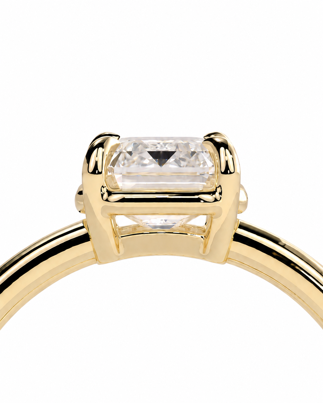 color_10K_YG, color_14K_YG &&A close-up of a yellow gold ring featuring a rectangular clear gemstone in a four-prong setting, shown against a plain white background.
