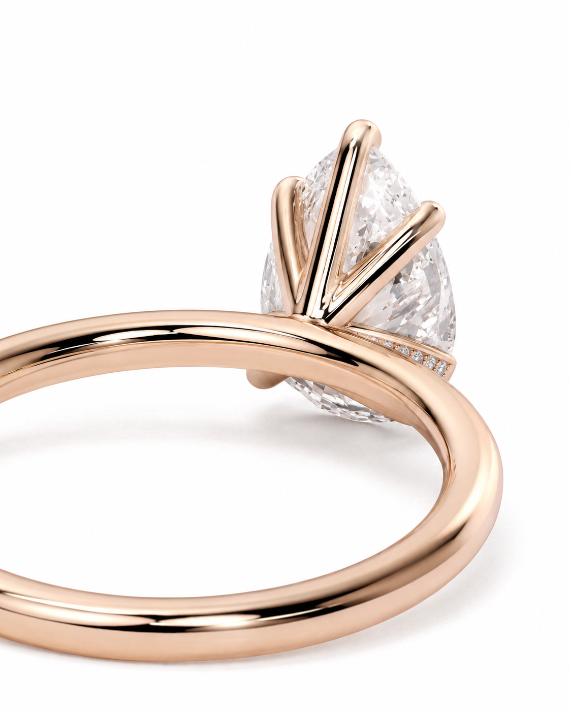 color_10K_RG, color_14K_RG &&
A close-up of a rose gold ring featuring a pear-cut clear gemstone in a multi-prong setting, shown on a clean white background.