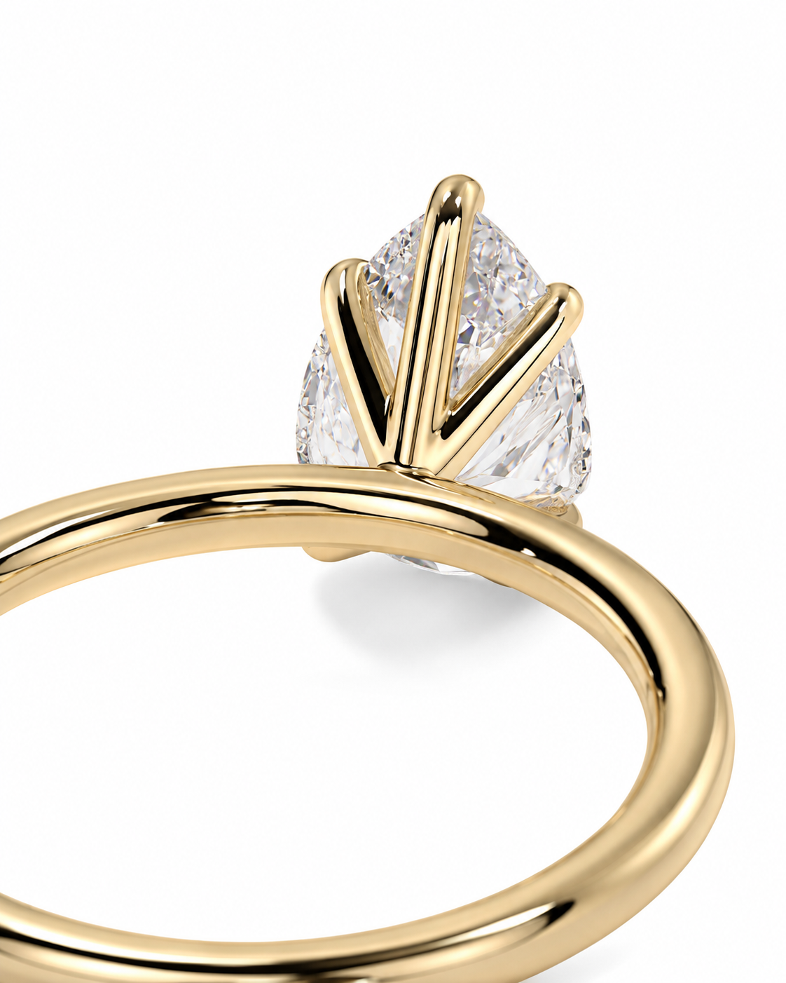color_10K_YG, color_14K_YG &&
A close-up of a gold ring featuring a pear-cut clear gemstone held in a unique prong setting, shown against a solid white background.