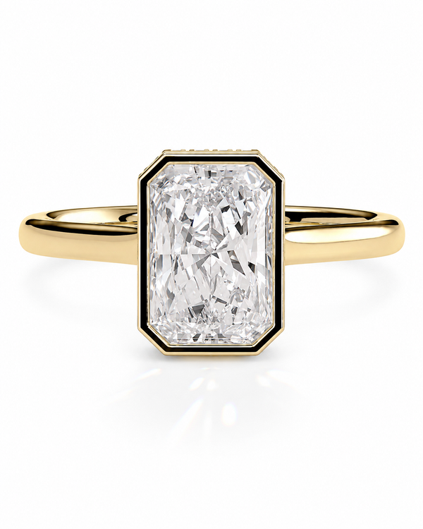 color_10K_YG, color_14K_YG &&A yellow gold ring featuring a large rectangular emerald-cut diamond center stone, set in a black bezel with a polished gold band, shown on a clean white background.