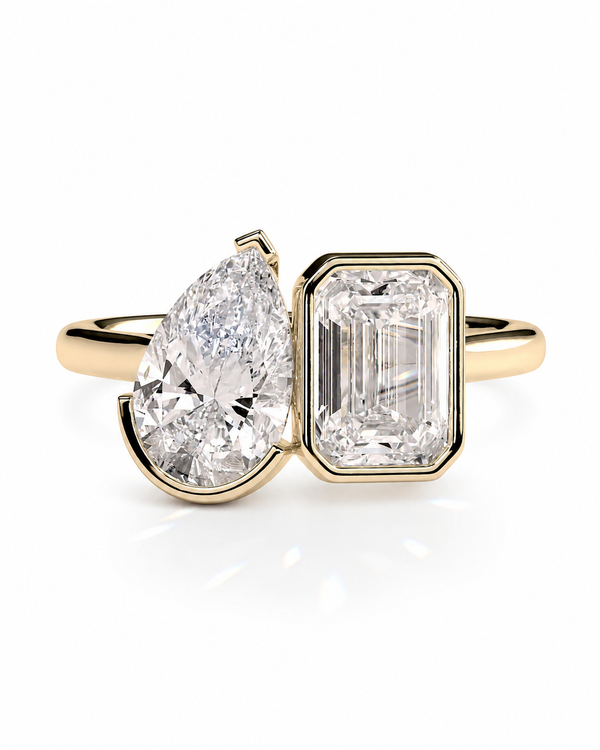 color_10K_YG, color_14K_YG &&A yellow gold ring featuring a pear-cut diamond on one side and an emerald-cut diamond on the other, set against a clean white background.