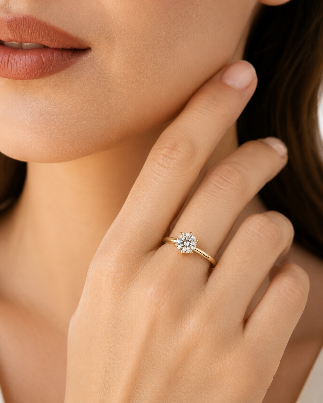 color_10K_YG, color_14K_YG &&A close-up lifestyle shot of a model wearing a yellow gold ring with a round-cut clear gemstone cluster setting on her finger.