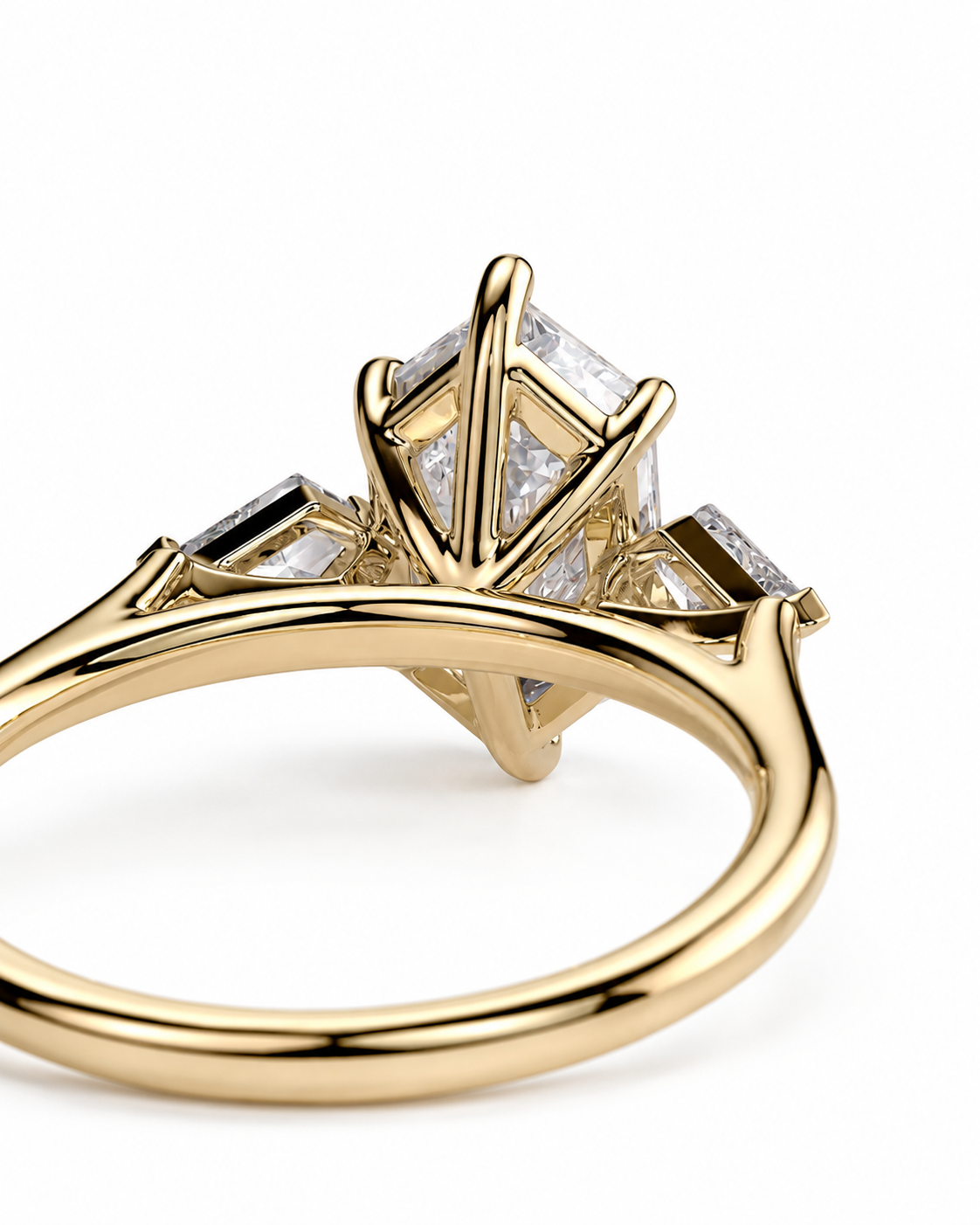 color_10K_YG, color_14K_YG &&A close-up shot of a yellow gold ring featuring a multi-stone setting with a central rectangular clear gemstone and smaller side stones, set against a plain white background.