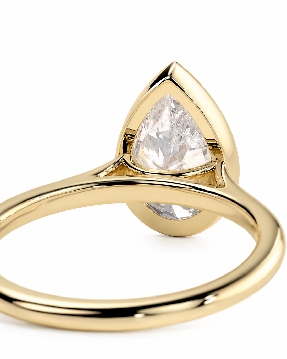 color_10K_YG, color_14K_YG &&A close-up shot of a gold ring featuring a pear-cut clear gemstone in a teardrop-shaped bezel setting, with a smaller round clear gemstone on the underside of the setting, on a white background.