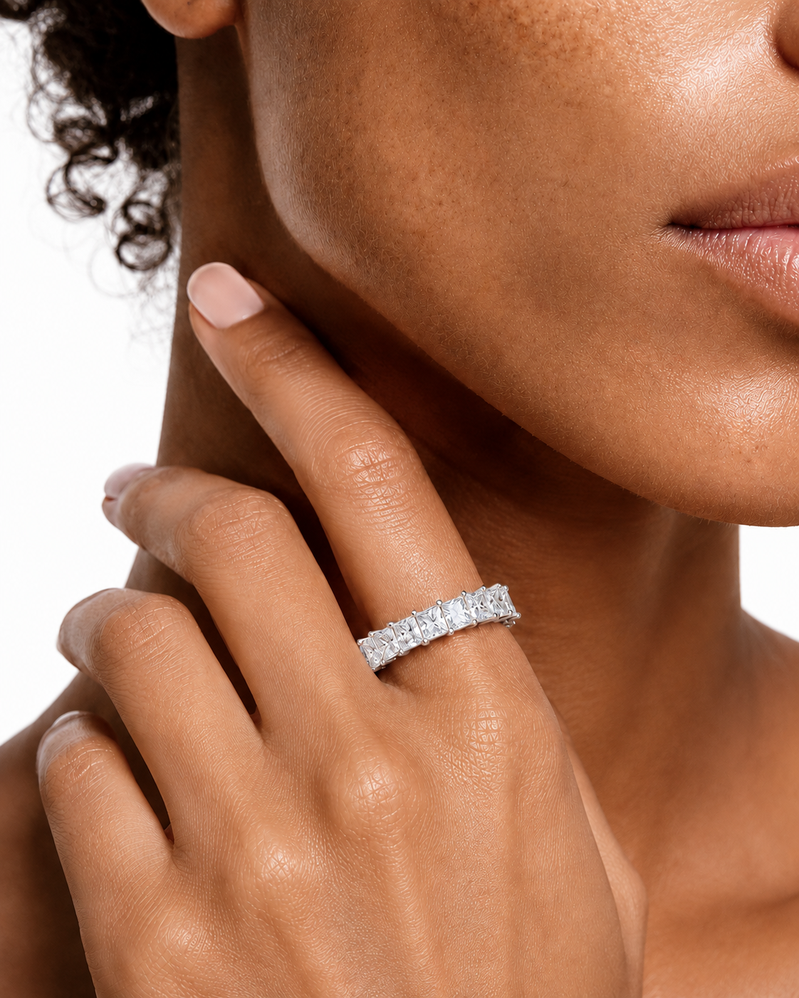 color_925_SIL,color_935_ARG,color_10K_WG, color_14K_WG &&	
A close-up lifestyle shot of a model wearing a sparkling diamond eternity band ring on her finger, with her hand resting near her neck against a clean white background.