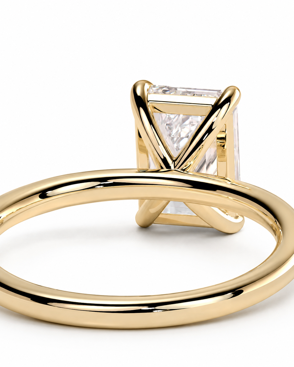 color_10K_YG, color_14K_YG &&
A close-up shot of a gold ring featuring a rectangular clear gemstone in a unique crisscross prong setting, shown on a clean white background.