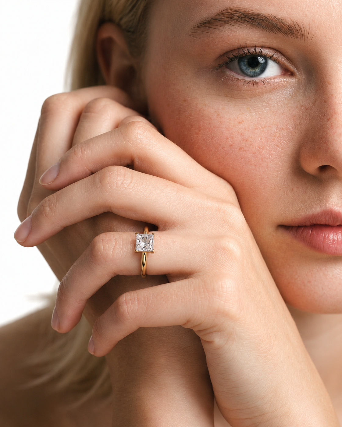 color_10K_YG, color_14K_YG &&A close-up lifestyle shot of a model wearing a gold ring with a square-cut clear gemstone on her finger, set against a clean white background.