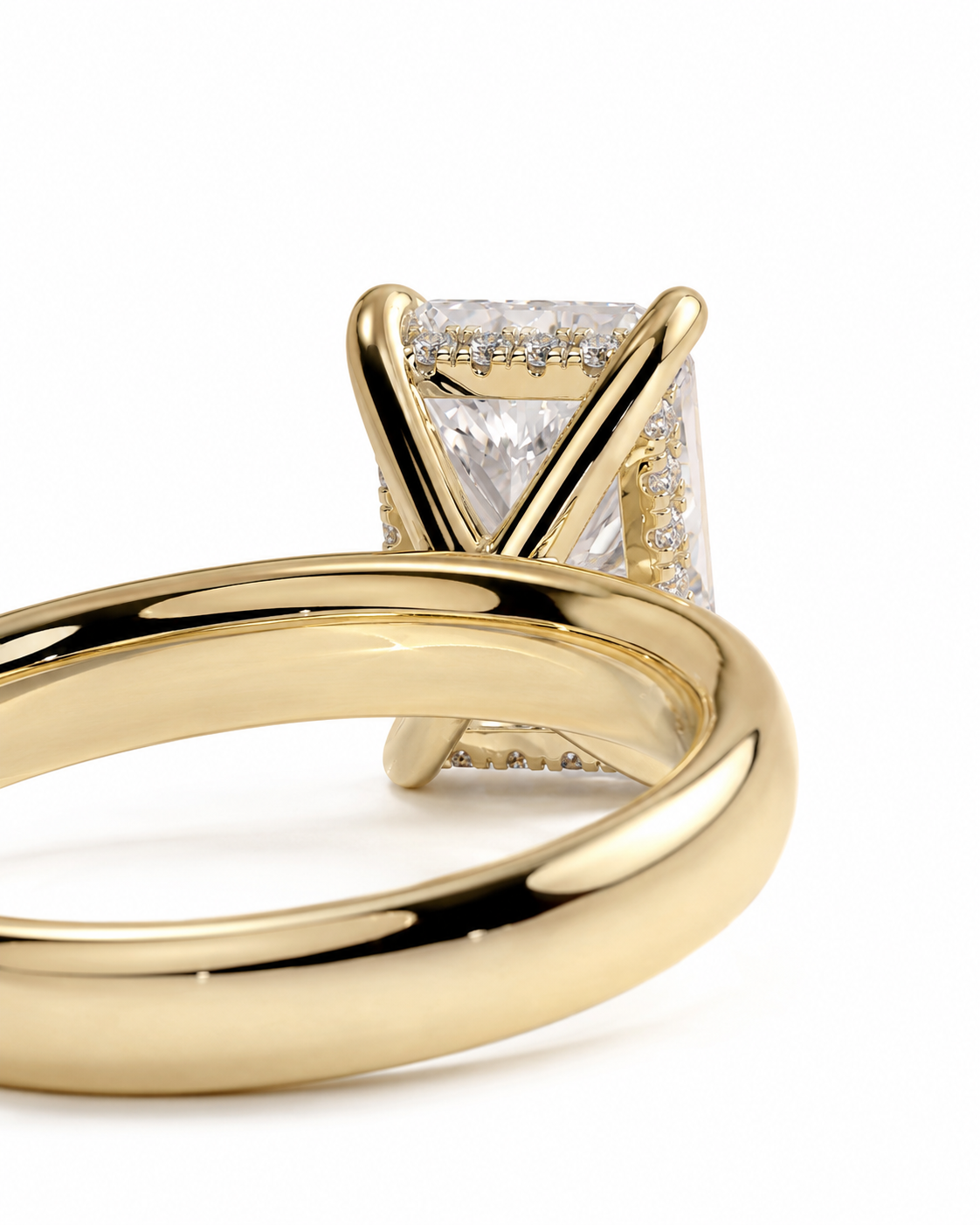 color_10K_YG, color_14K_YG &&A close-up of a yellow gold ring featuring a rectangular clear gemstone in a prong setting, with a polished band shown from an angle against a white background.