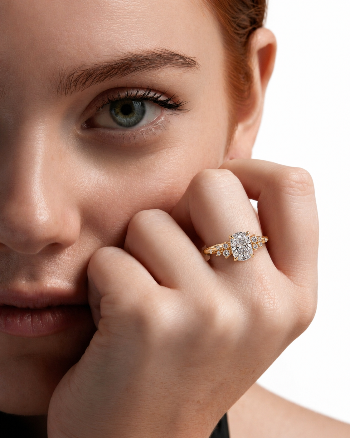color_10K_YG, color_14K_YG &&A close-up lifestyle shot of a model wearing a yellow gold ring with a large oval-cut clear center stone and smaller side stones, set against a clean white background.