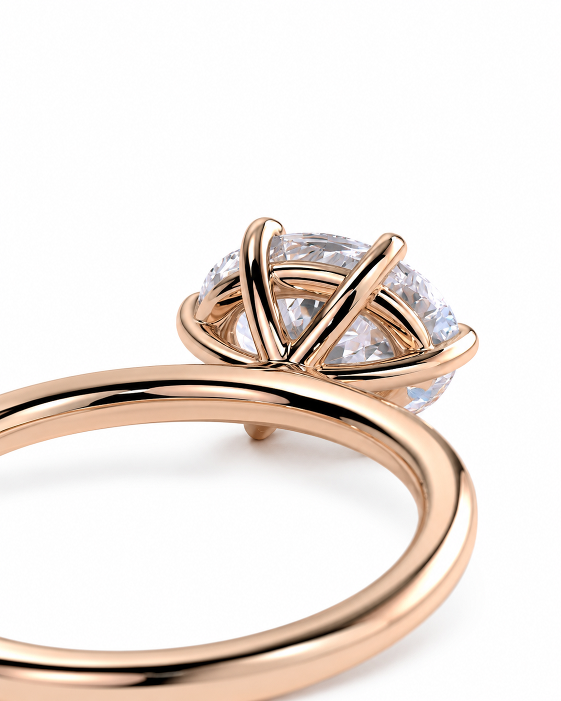 color_10K_RG, color_14K_RG &&
A close-up of a rose gold ring with a round brilliant-cut clear gemstone in a unique crisscross prong setting, shown on a clean white background.