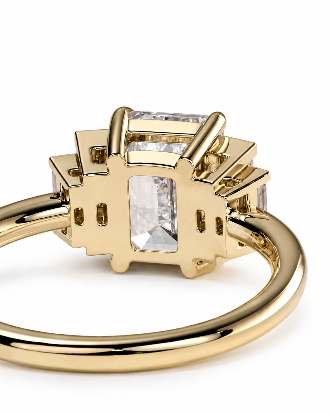 color_10K_YG, color_14K_YG &&A close-up shot of a yellow gold ring featuring a unique geometric setting with clear rectangular and marquise-cut gemstones, set against a plain white background.