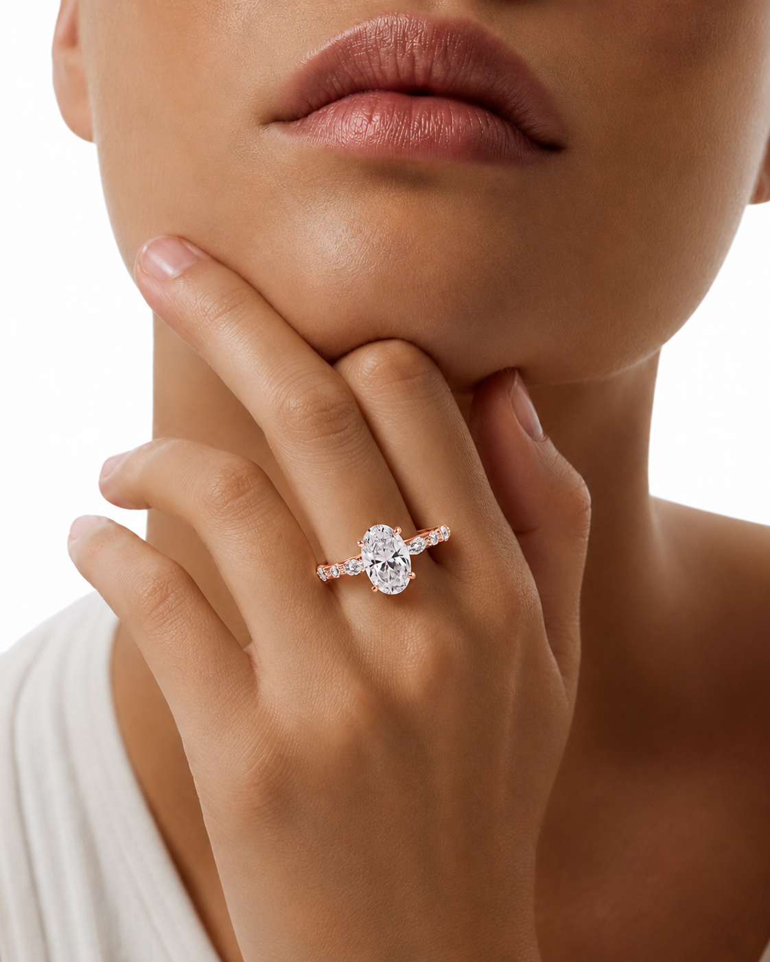 color_10K_RG, color_14K_RG &&
A close-up of a model's hand and lower face wearing a silver ring with a large round-cut center stone and smaller side stones.