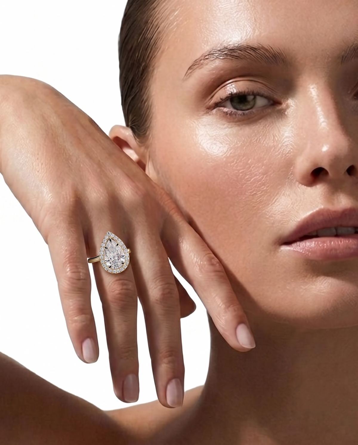 color_10K_YG, color_14K_YG &&A close-up lifestyle shot of a model wearing a yellow gold diamond engagement ring on her finger, with her hand resting against her cheek against a clean white background.