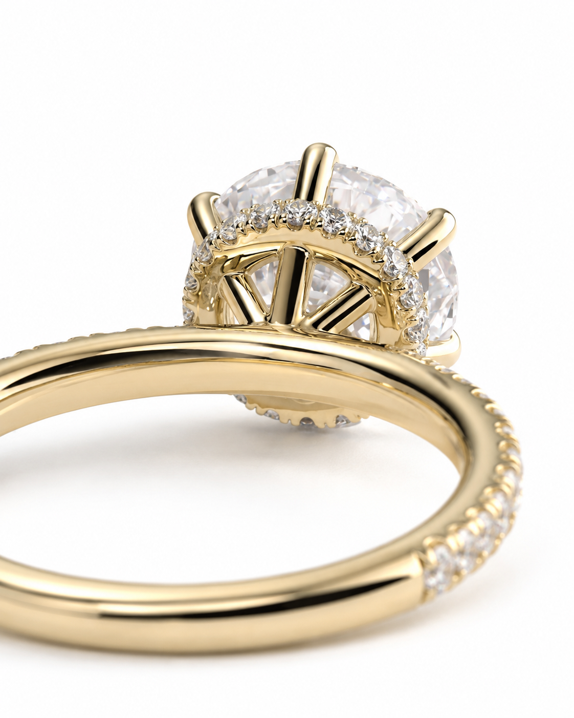 color_10K_YG, color_14K_YG &&
A close-up shot of a yellow gold ring featuring a large round clear gemstone in a prong setting, surrounded by a halo of smaller diamonds, with a shank paved with small diamonds, on a white background.
