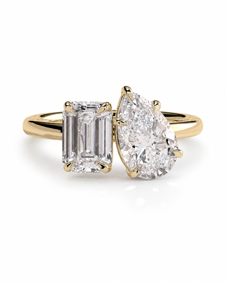 color_10K_YG, color_14K_YG &&A yellow gold ring featuring a rectangular emerald-cut diamond on the left and a pear-cut diamond on the right, set against a clean white background.