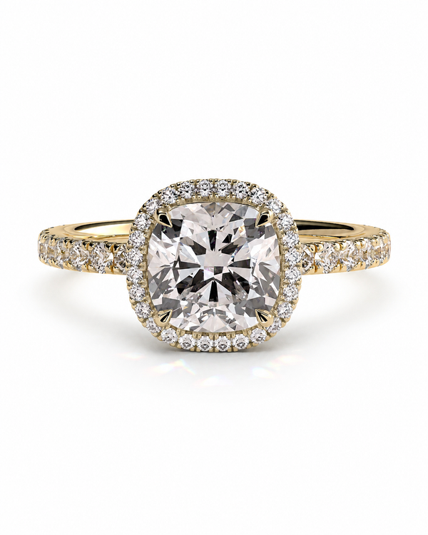 color_10K_YG, color_14K_YG &&A yellow gold halo ring featuring a large cushion-cut center stone surrounded by a halo of small clear stones, with additional pavé stones along the shoulders, set against a plain white background.
