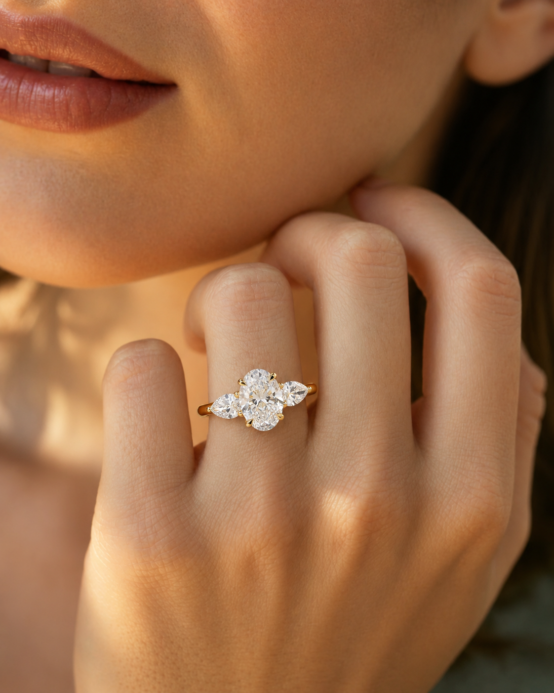 color_10K_YG, color_14K_YG &&
A close-up lifestyle shot of a woman wearing a yellow gold ring with a diamond cluster setting on her finger.